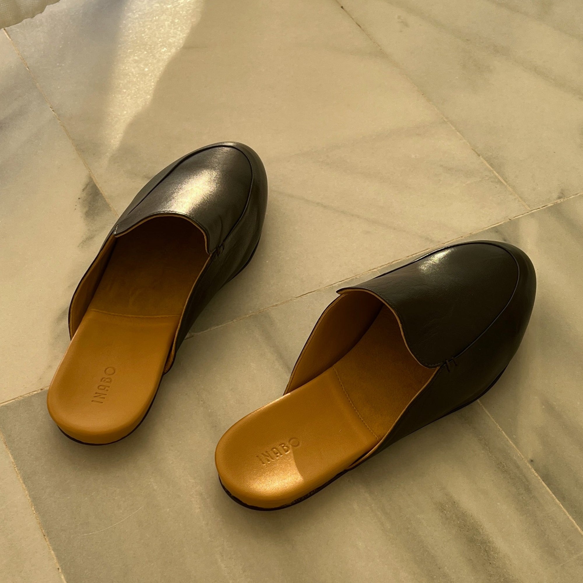 Dark brown leather slippers from Inabo with a yellow leather insole